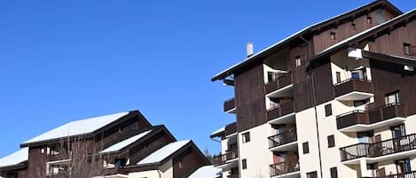 A multi-story hotel with balconies and a snow-covered roof.