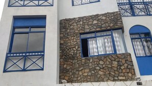 Un hôtel à la façade en pierre, aux fenêtres encadrées de bleu et à l’enseigne portant l’inscription « ktowaves HOTEL ».