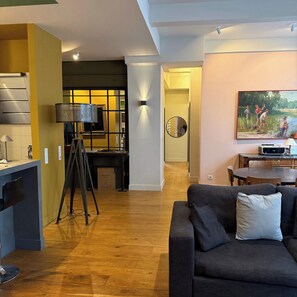 A modern living space with a kitchen, dining area, and a sofa.
