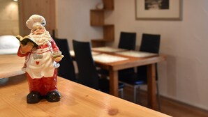 Un tavolo da pranzo con sedie, un mobiletto in legno e un quadro appeso al muro.