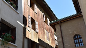 Un edificio con persiane in legno, un balcone e una finestra vista.