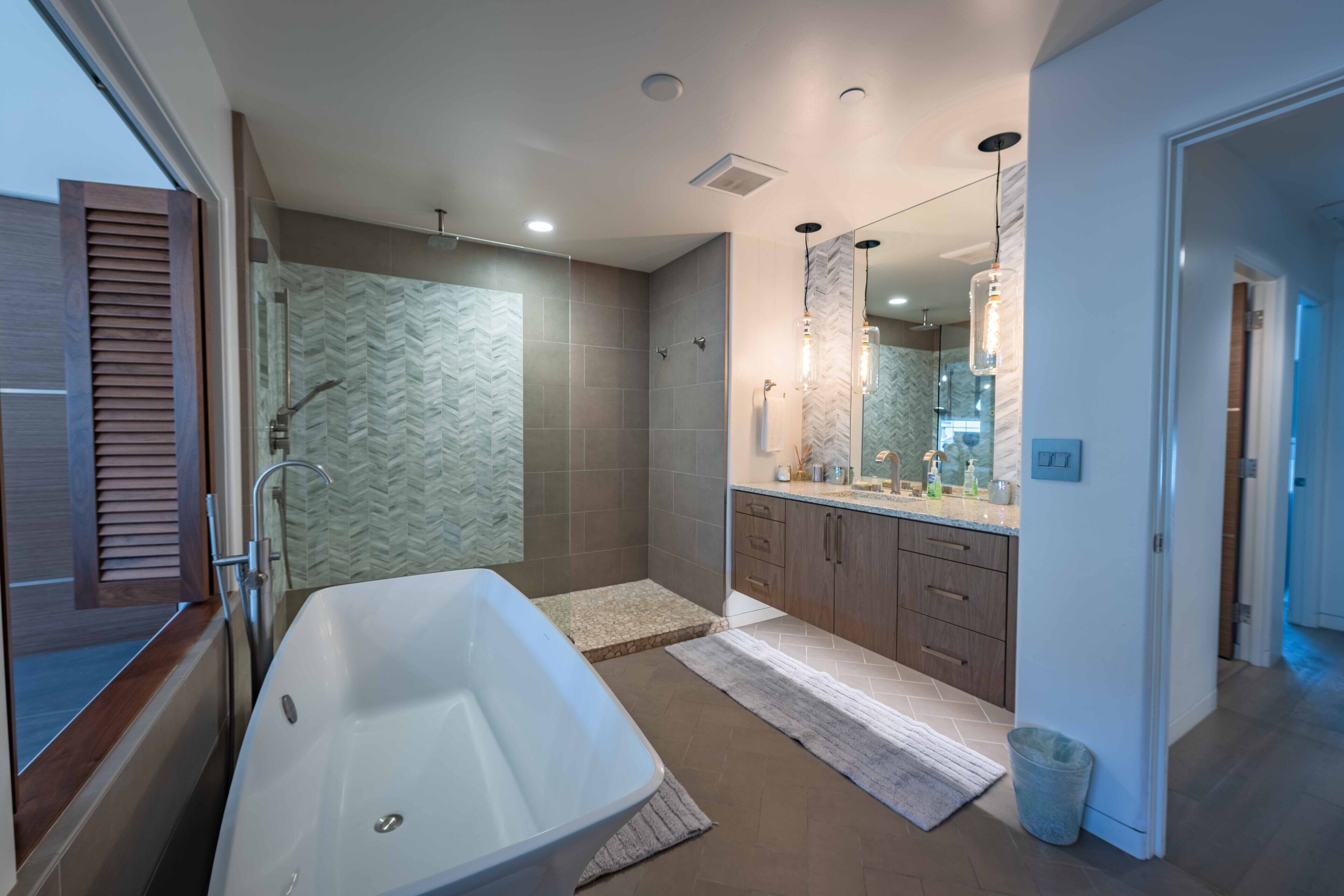 A modern bathroom with a freestanding bathtub, a walk-in shower, and a vanity with a mirror.