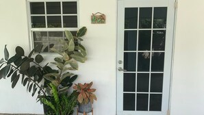 A white building with a door and windows. There are potted plants in front of the door. - Modern & Private Sun Valley getaway for two (Sun Valley)