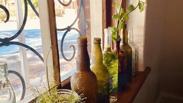 Una estantería de madera con varias botellas de vidrio y una pequeña planta en maceta.