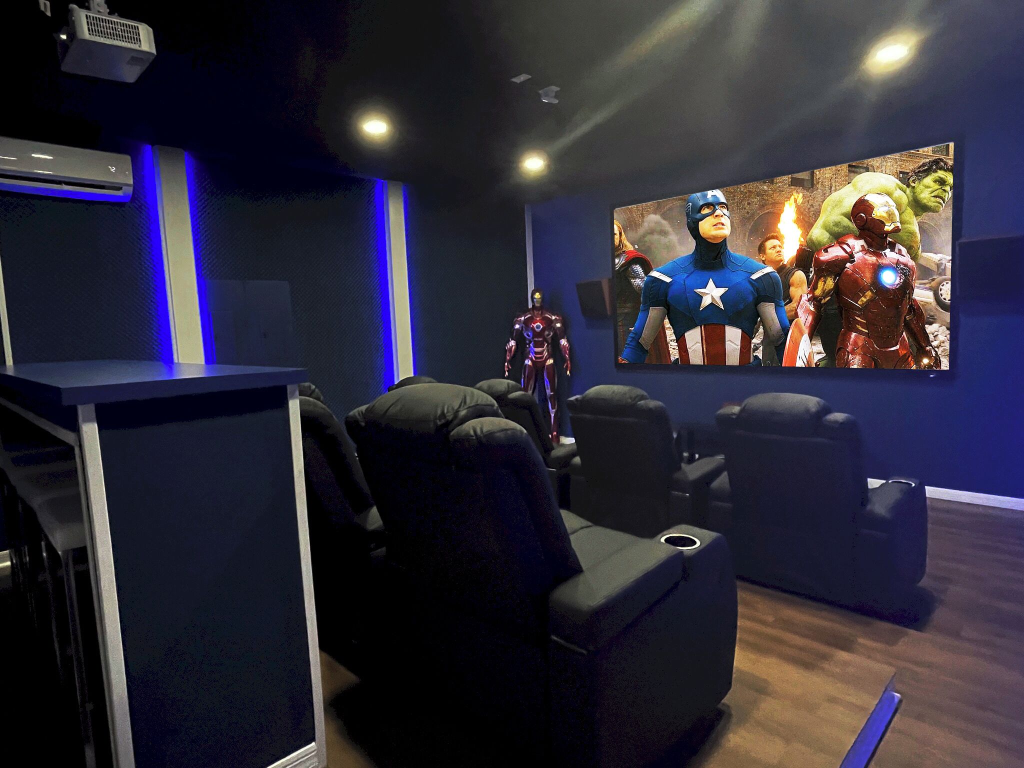Une salle de cinéma privée équipée d’un grand écran, de fauteuils inclinables et d’un système audio de qualité.