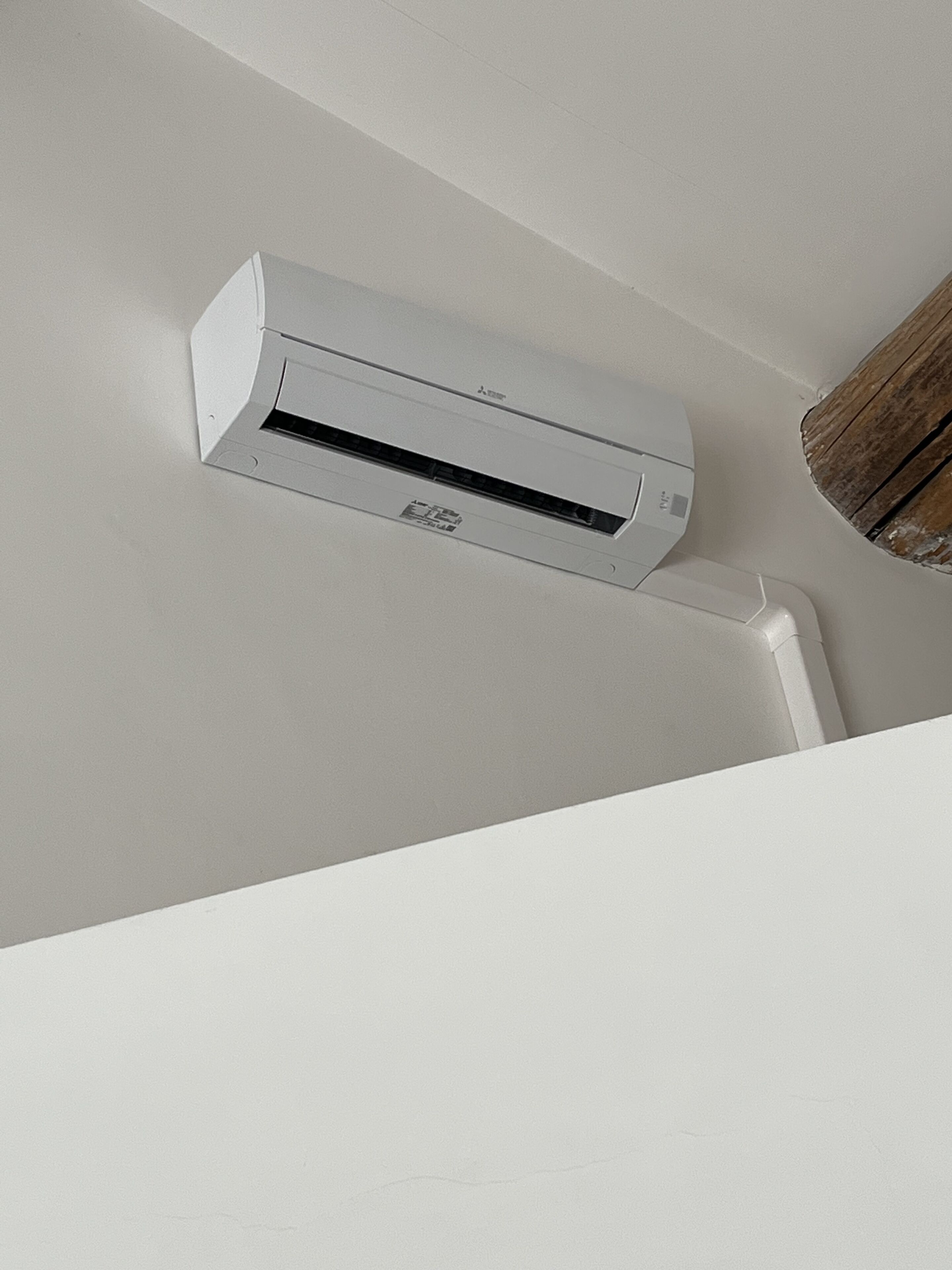 Un climatiseur blanc est fixé sur un mur blanc.
