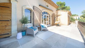 A patio with outdoor seating, a potted plant, and a tiled floor. - Panoramic 4-BR Villa near Aix w/Pool, AC - for 10 people (Le Tholonet (13100))