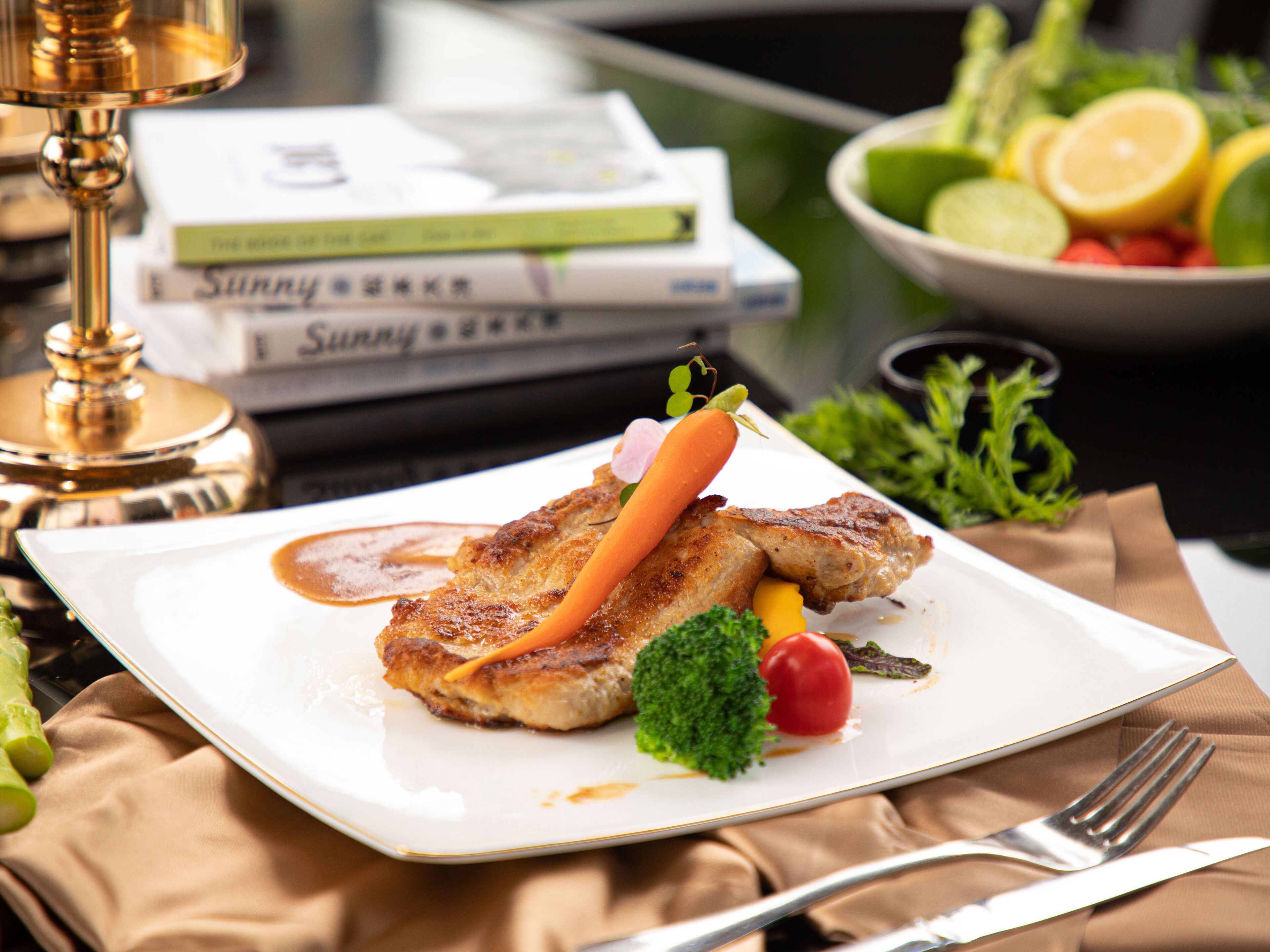 A plate with food, a fork, and a book.