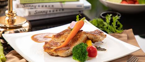 A plate with food, a fork, and a book.
