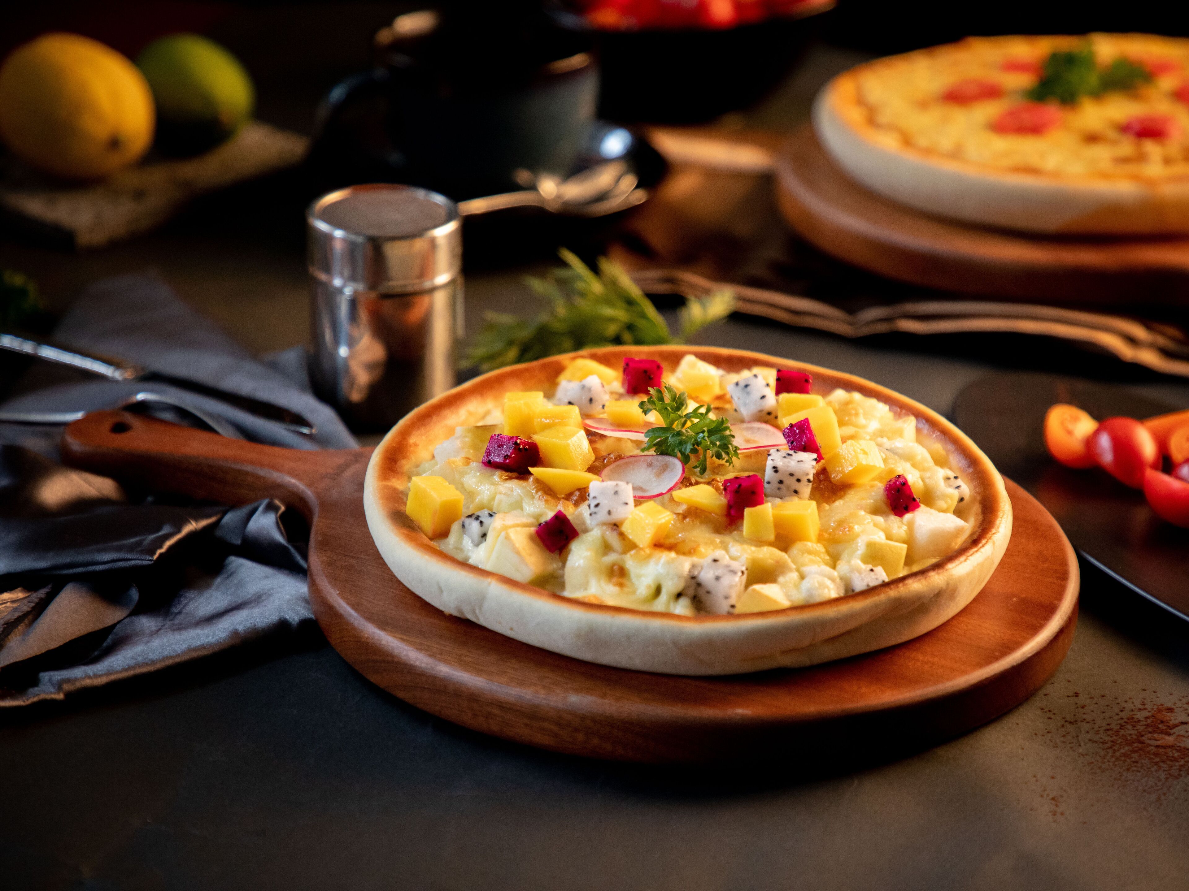 A pizza with toppings on a wooden board.