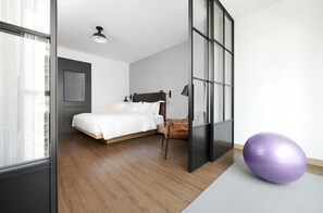 A modern hotel room with a bed, a yoga ball, and a large window. - Moxy Shenzhen North Station (Shenzhen)
