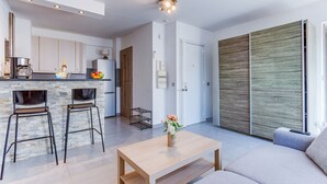 A modern kitchen with a coffee machine, a fruit bowl, and a bar stool. - SUEDE 4 - balcon & clim, à 100 m plage - By Rivier (Niza)