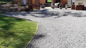 A simple, functional home with a gravel driveway and well-manicured lawn.