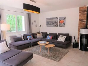 A modern living room with a sectional sofa, a round coffee table, and a fireplace.