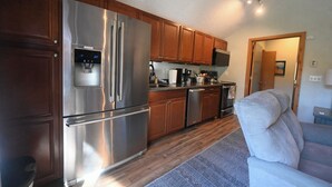 A modern kitchen with stainless steel appliances, wooden cabinets, and a built-in water dispenser. - Shanty Creek/ Schuss Close to lakes boat parking. golf course Sleeps 2 adults. (Mancelona)
