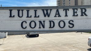Schild für Lullwater Condos, mit freier Sicht auf den umliegenden Parkplatz und Hochhäuser im Hintergrund.