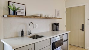 A modern kitchen with white cabinetry, a built-in oven, and a stainless steel sink. - South Lake Chalet #2 (South Lake Tahoe)