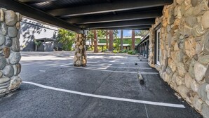 Un área de estacionamiento techada con muros de piedra y vista despejada de edificios al fondo.