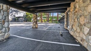 A covered parking area with stone walls and a clear view of the surrounding buildings.
