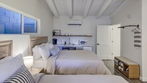 A bedroom with two beds, a kitchenette, and a bathroom. - South Lake Chalet #11 (South Lake Tahoe)