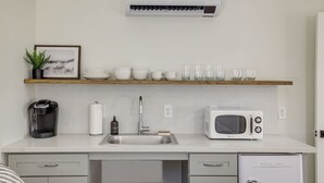 A compact kitchen with a white countertop, a built-in microwave, a coffee maker, and a small refrigerator. - South Lake Chalet #11 (South Lake Tahoe)