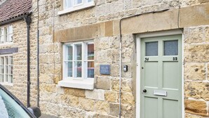 A stone building with a green door labeled "34" and "32". - Host & Stay | Willow Cottage (Helmsley)