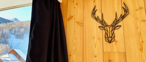 A room with a wooden wall and a deer head decoration.
