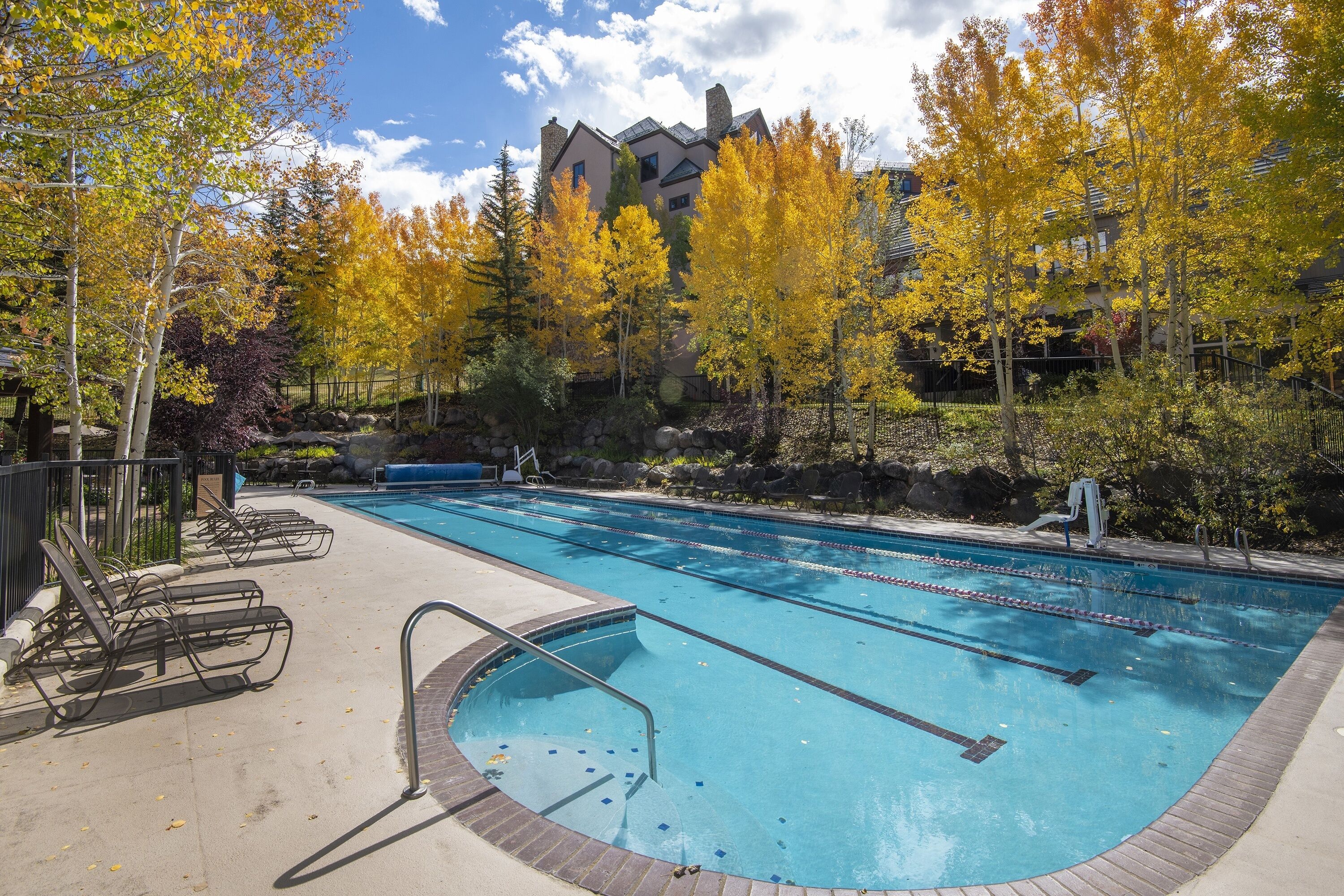 A swimming pool with lounge chairs and a stone pathway leading to the pool.