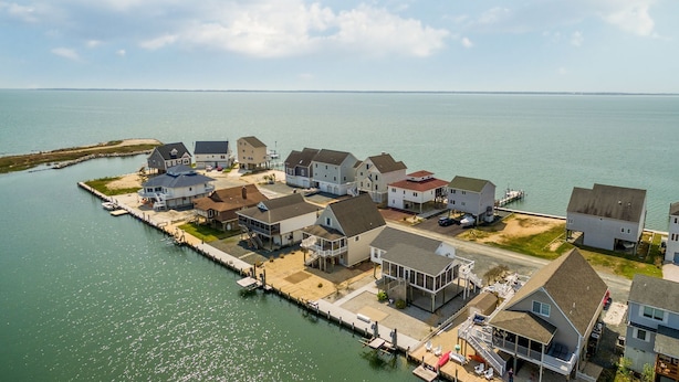 A coastal residential area with houses connected by a dock.