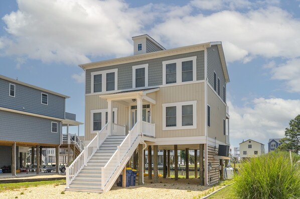 A two-story house with a covered porch and a staircase leading to the second floor. - Statuesque waterfront home by Seaside Vacations & Sales (Greenbackville)