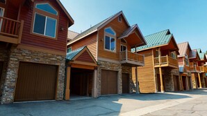A row of modern, multi-story houses with wooden exteriors and stone accents. - Mammoth Gateway Village 7 Pet-Friendly, Mountain Modern with Private Jacuzzi and 2 Car Garage by RedAwning (Mammoth Lakes)