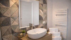 A modern bathroom with a large oval sink, a mirror, and a towel rack. - Suite con Terrazzo, Parcheggio Gratuito – Lecce (Castromediano)