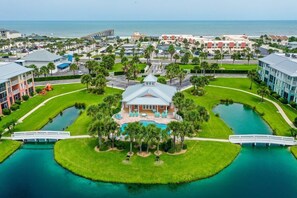 A large resort with a central pool, multiple bridges, and a view of the ocean. - Seaside Escape l Steps to Beach l Heated Pool (St. Augustine)