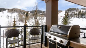 A balcony with a grill and two wicker chairs overlooking a snowy landscape with a ski lift. - Ski-In & Out Your Doorstep! Pool/Hot Tub, Great Village Access!! (Beaver Creek)