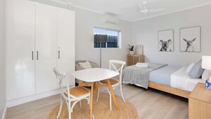 A bedroom with a bed, a bedside table, a window, and a wardrobe. - Wild Rose Studio, 100M to the water (Goolwa South)