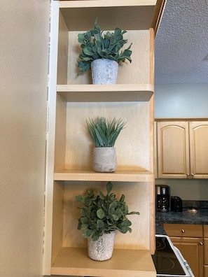 Een keuken met houten planken waarop potplanten staan.