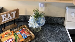 A kitchen with a countertop, a toaster, a bowl, a glass container, and a sign with the word "EAT". - 2 Story Townhouse walk to Atlantic Ave (Delray Beach)