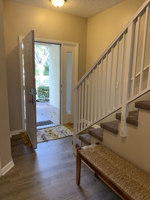Enter a serene hallway leading to an outdoor space.