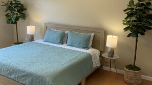 A bedroom with a bed, two bedside tables with lamps, and two potted plants. - 2 Story Townhouse walk to Atlantic Ave (Delray Beach)