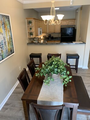 Enjoy meals in this dining area with a large potted plant and comfortable seating for six.