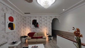 Ein modernes Wohnzimmer mit einer Couch, einem Couchtisch und Zimmerpflanzen.