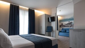 A modern hotel room with a bed, a desk, a chair, and a TV. - Cesare Augustus (Jesolo)