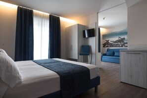 A modern hotel room with a bed, a desk, a chair, and a TV. - Cesare Augustus (Jesolo)