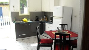 Uma cozinha compacta com área de refeições, com pia, fogão, micro-ondas e armários.