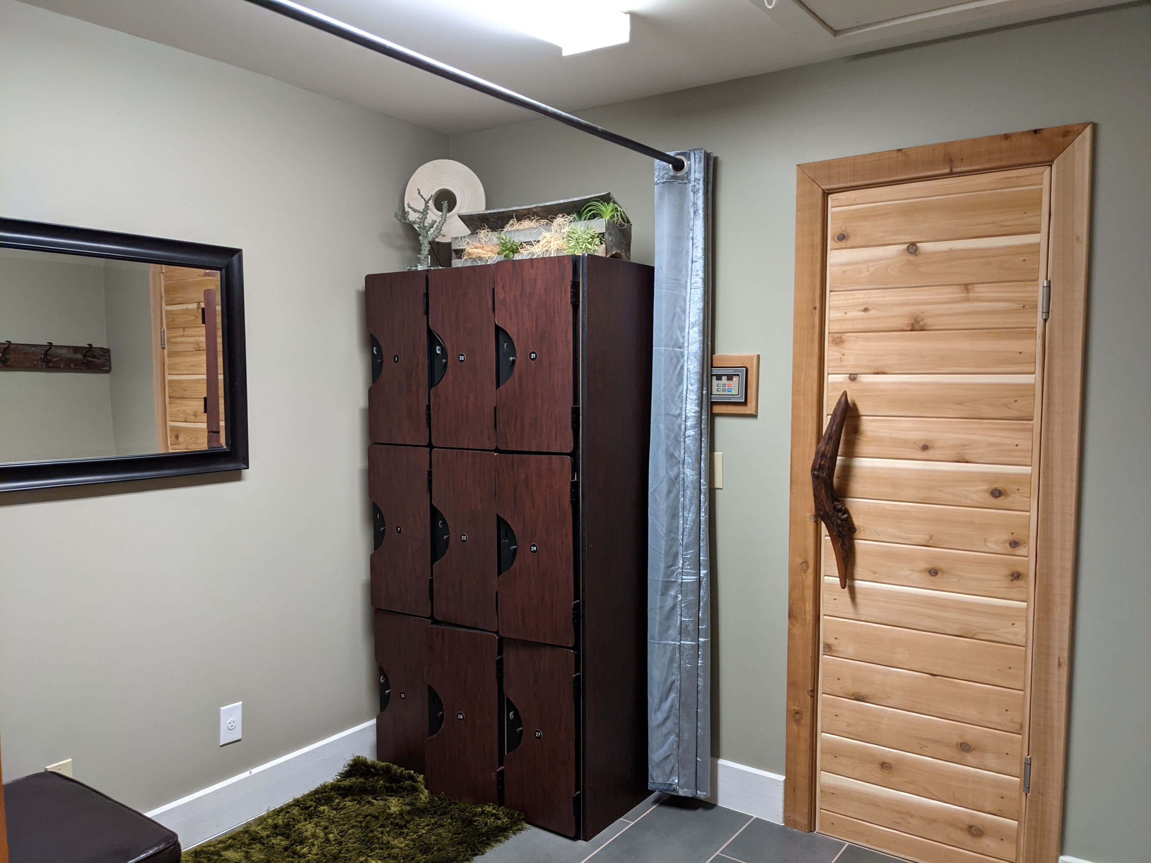 A hallway with a wooden wardrobe, a mirror, and a wooden door.