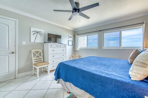 Relax in this serene bedroom with a large bed, dresser, and comfortable chair.