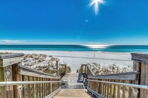 Walk along the boardwalk to the ocean's edge, where the sandy shore meets the sea.