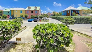A residential area with colorful houses, a roundabout, and a parking lot.