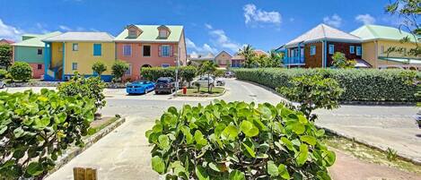 A residential area with colorful houses, a roundabout, and a parking lot.