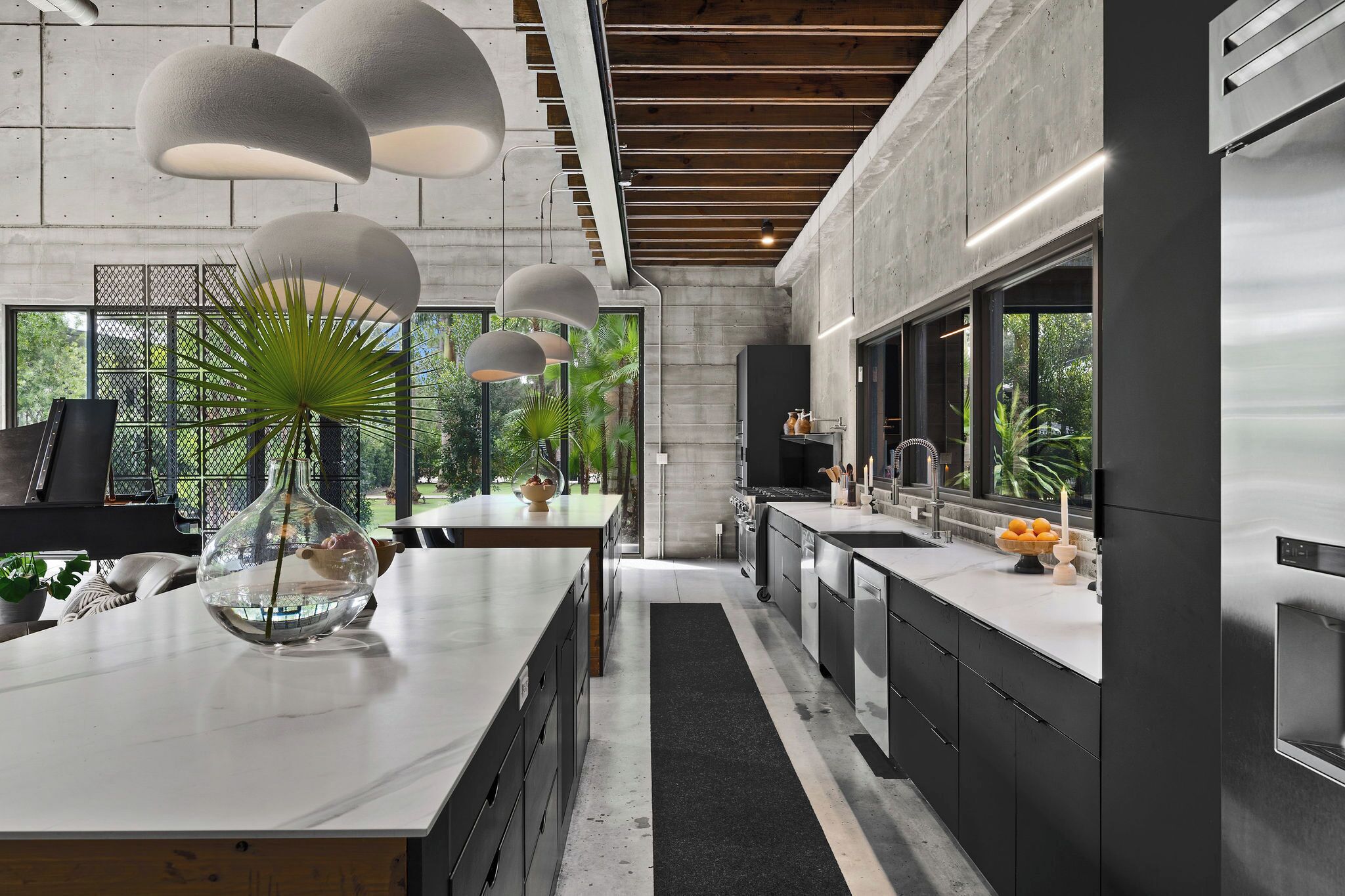 A modern kitchen with a central island, stainless steel appliances, and pendant lighting.